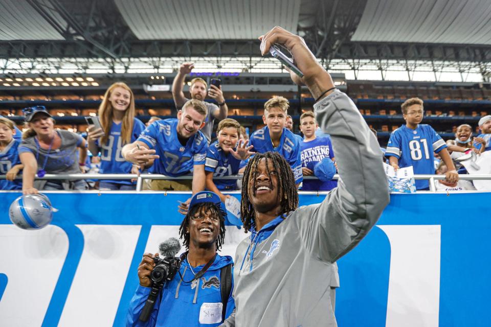 Lions wide receiver Jameson Williams takes a selfie with fans after open practice at Family Fest at Ford Field on Saturday August 6, 2022.