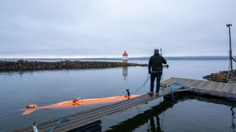 An autonomous underwater vehicle named Hugin (left) surveys a Norwegian lake.
