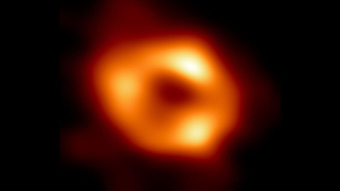 A glowing orange ring indicates the event horizon of the Milky Way's giant black hole, Sagittarius A*.