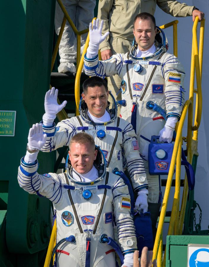 Dmitri Petelin of Roscosmos, top, Frank Rubio of NASA, and Sergey Prokopyev of Roscosmos, bottom, wave goodbye before boarding the Soyuz spacecraft MS-22 to go to the ISS on September 21, 2022.