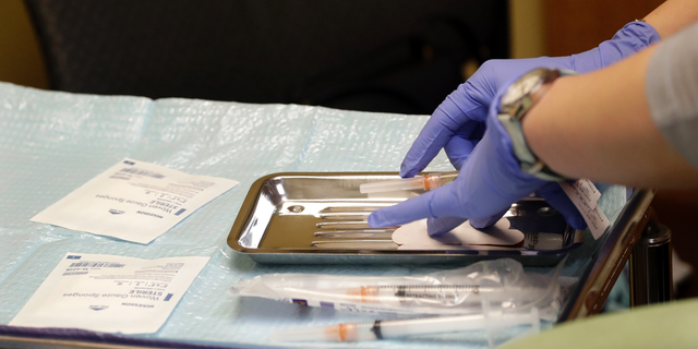 A healthcare worker prepares syringes, including a measles, mumps and rubella (MMR) vaccine, for a child's inoculations at International Community Health Services in Seattle.  Officials in the Pacific Northwest say a measles outbreak that sickened several people is over.