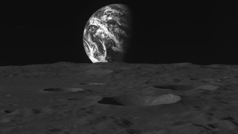 The surface of the moon can be seen to be heavily cratered as the Earth rises above it.