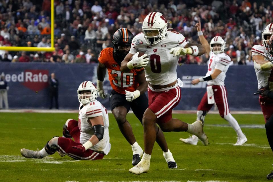 Wisconsin running back Braelon Allen (0) scores a touchdown against Oklahoma State in the second half of the NCAA Rate Guaranteed college football game Tuesday, Dec. 27, 2022 in Phoenix.  Wisconsin 24-17.