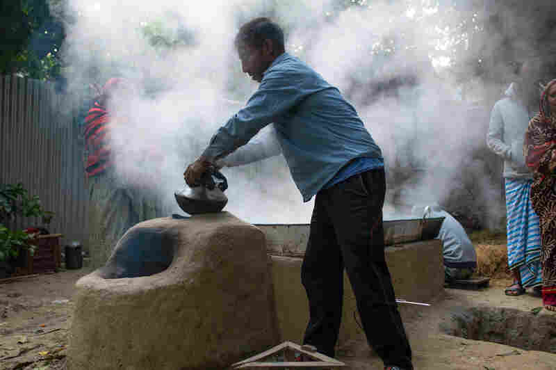 A man boils raw date palm sap into molasses, a traditional delicacy in Bangladesh.