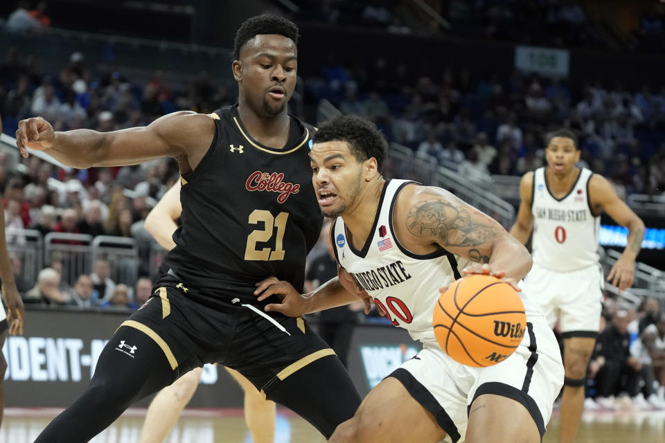 San Diego State guard Matt Bradley (20) drives past Charleston guard Jaylon Scott (21) during the first half of a first-round college basketball game in the NCAA Tournament on Thursday March 16, 2023 in Orlando, Fla. (AP Photo/ Chris O'Meara)